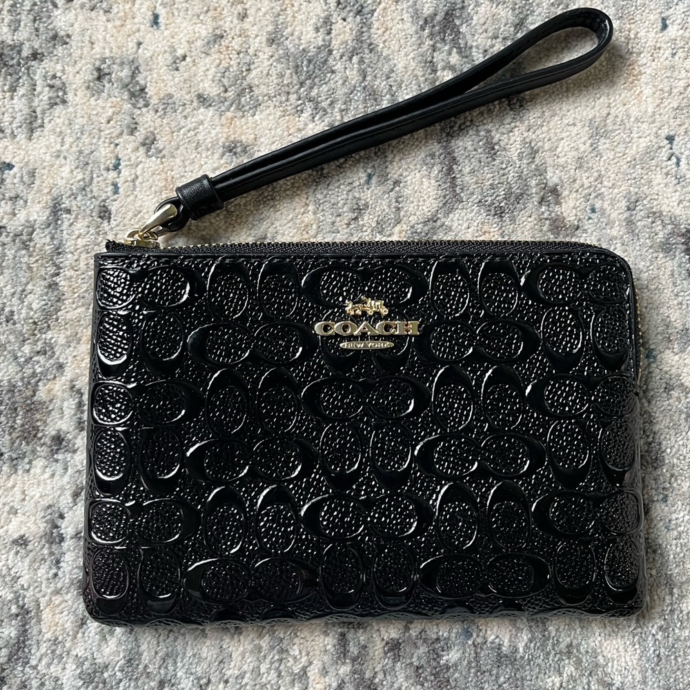 Coach wristlet in black paten leather with embossed logo
